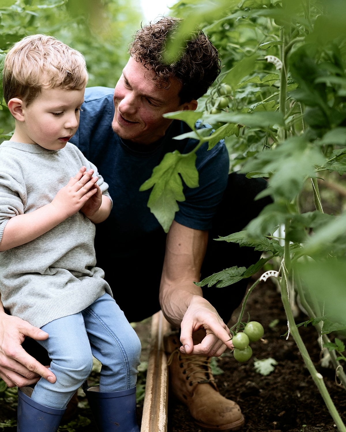 Paul Dingemans met zijn zoon tussen de tomatenplanten